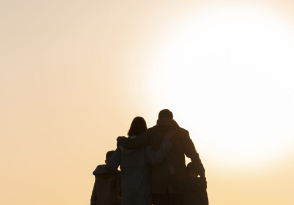 A group of people standing in a field with the sun in the background - personifying enduring wealth, legacy, multi-generational blessings.