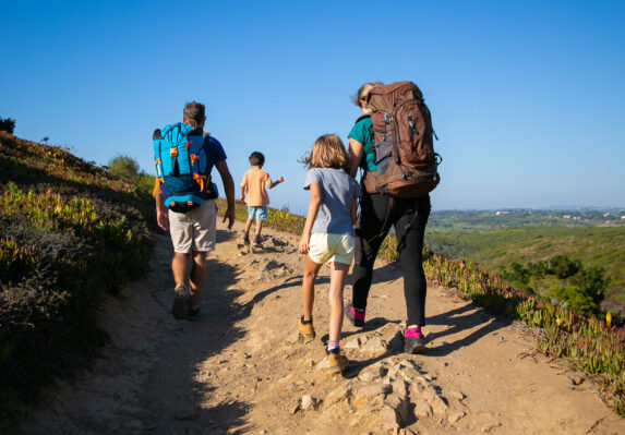 A family hiking on a dirt path - signifying adventure, risk management, etc.