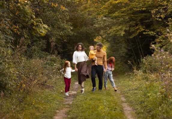 Health and wealth connection - Family walking through autumn forest path.